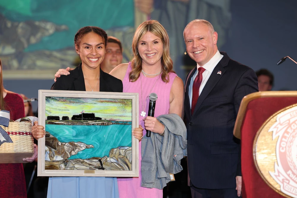 People posing with stained-glass piece.